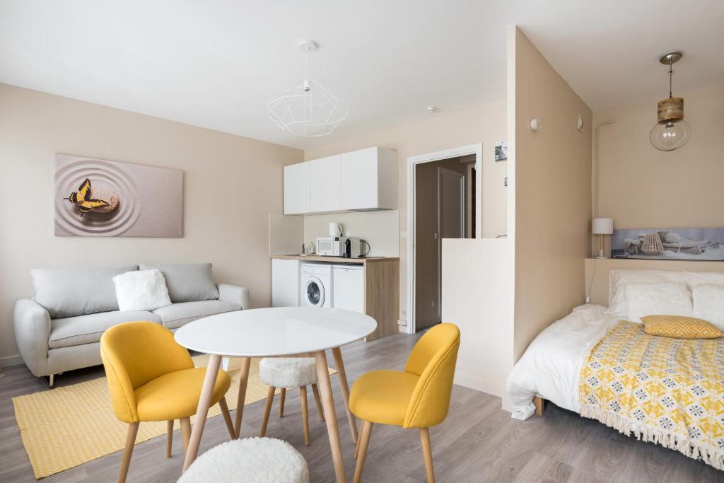 Habitación pequeña con cama, mesa y sillas en Appartement Lyon Gerland - Enjoy in Lyon, en Lyon
