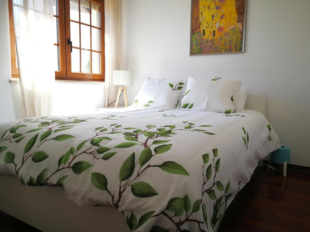 a bedroom with a bed with green leaves on it at Sintra 23 in Sintra