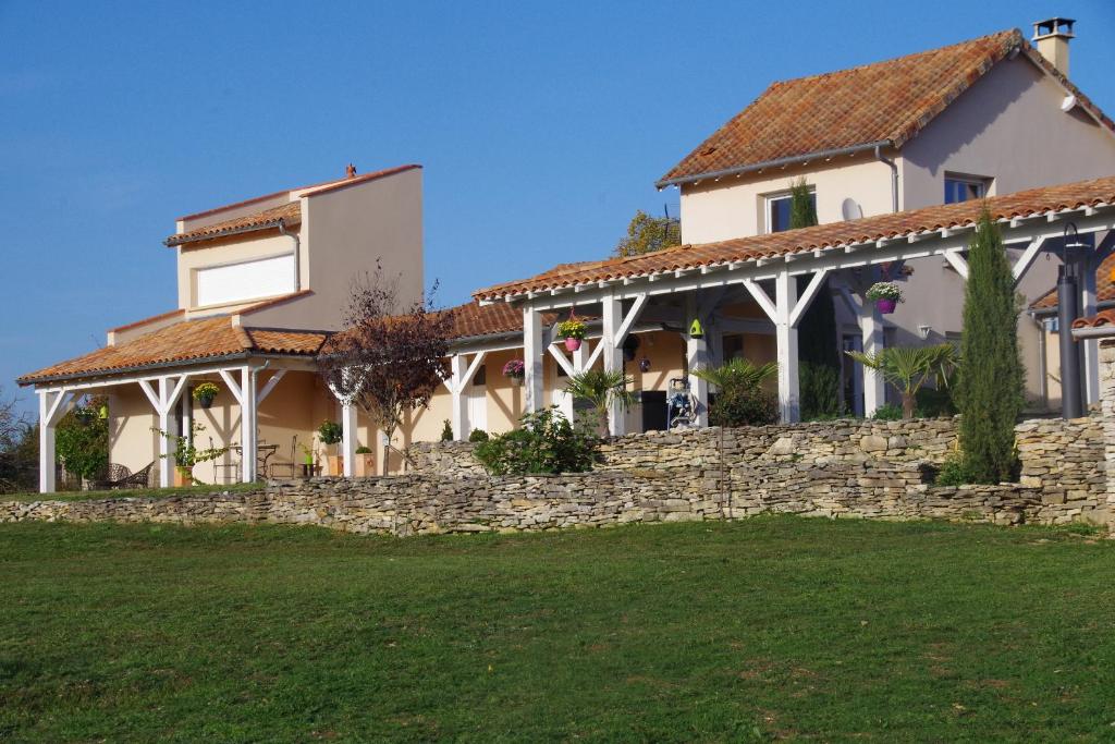 a house with a stone wall in front of a yard at Junior Suite Le Pied de Mulet in Brouchaud