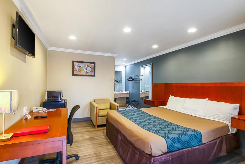 聖貝納迪諾的住宿－Econo Lodge San Bernardino I-215，配有一张床和一张书桌的酒店客房