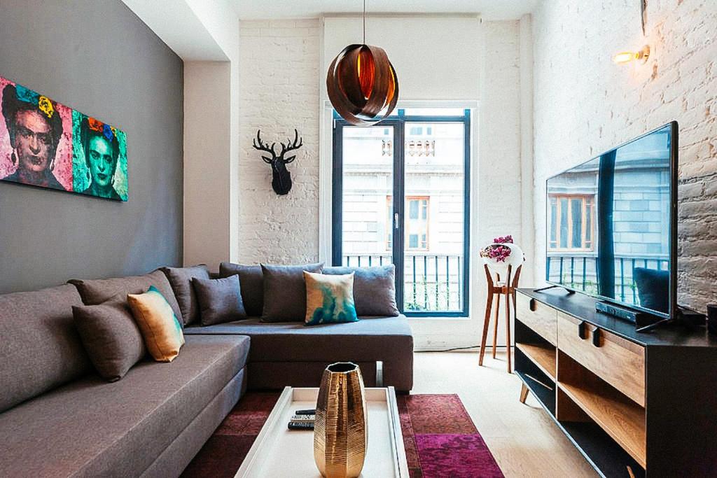 Una sala de estar con un sofá y un televisor. en My Place Donceles, en Ciudad de México