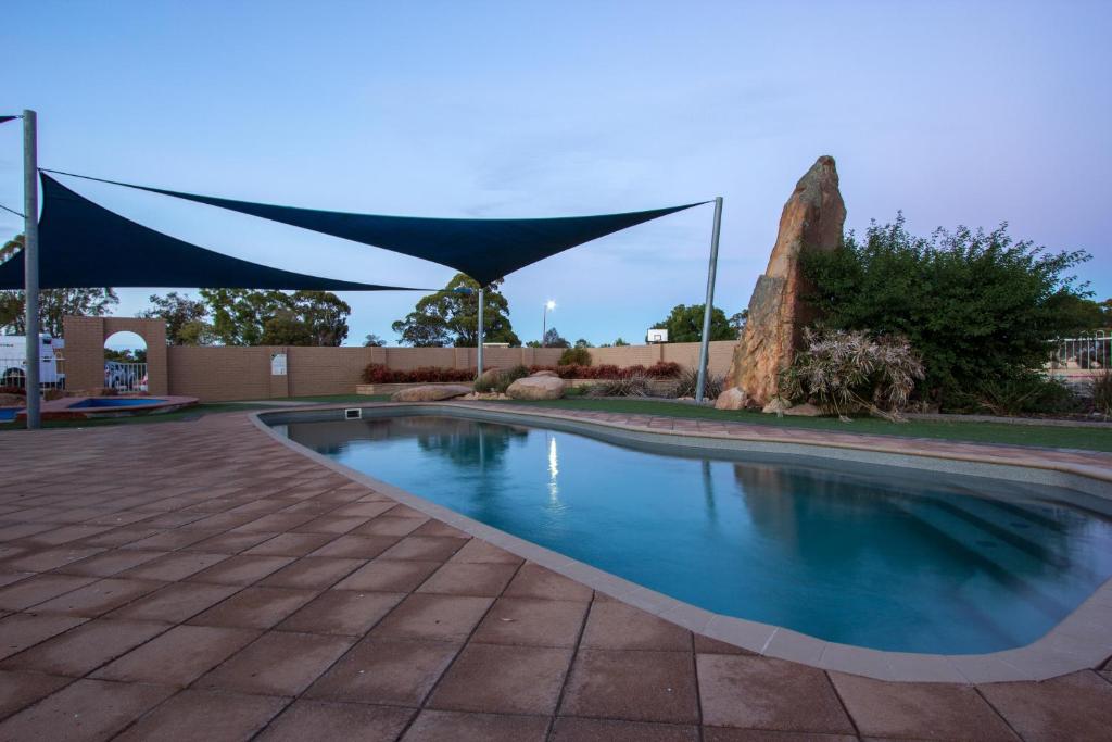 a swimming pool with a blue canopy over it at Horsham Holiday Park in Horsham