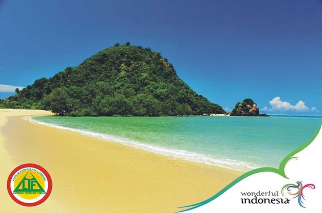 una spiaggia con una piccola isola nell'oceano di Sasak Lombok Bungalow a Kuta Lombok