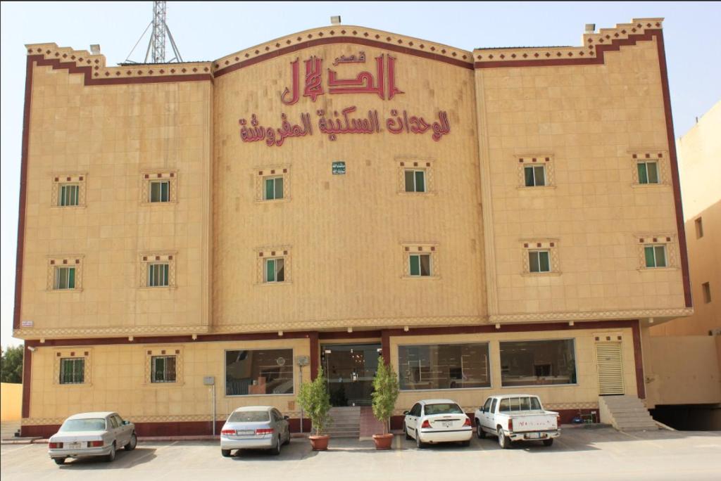 un gran edificio con coches estacionados frente a él en Al Dalal Palace 1, en Riad
