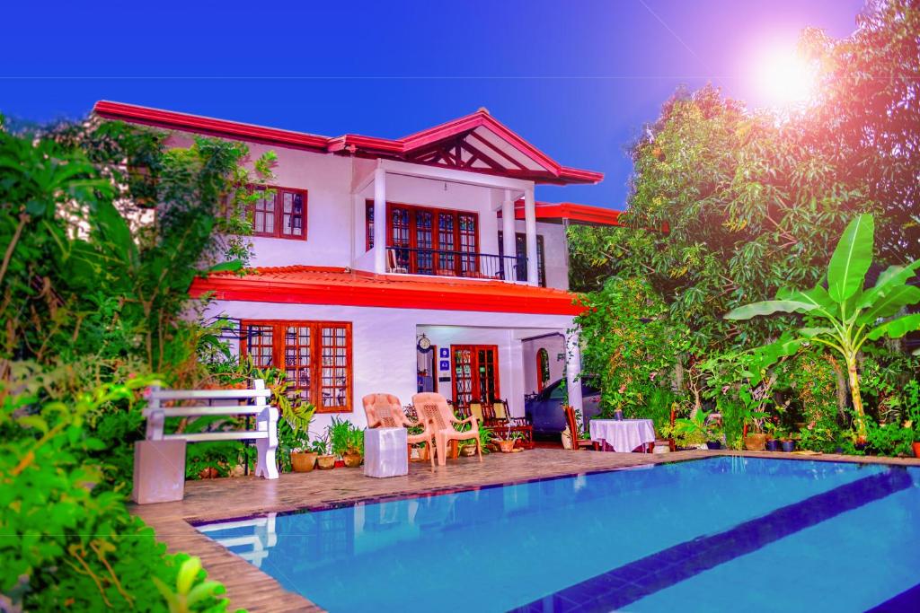 uma casa com piscina em frente a uma casa em Villu Villa em Anuradhapura