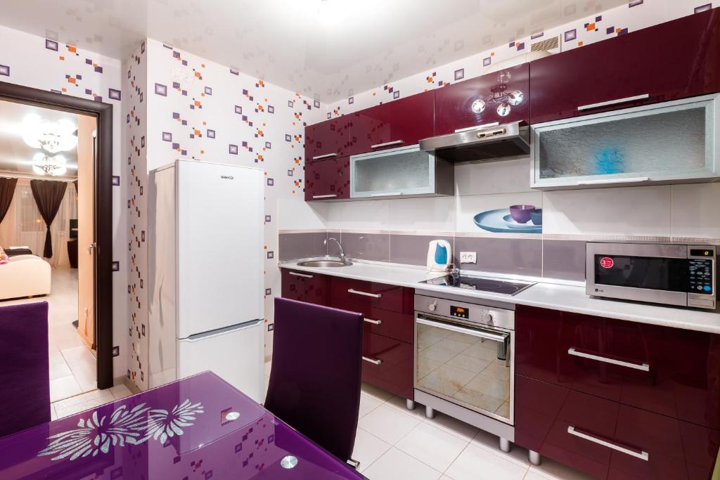 トムスクにあるKvartiry na Rozy Liuksiemburghの紫色のキャビネットと紫色のテーブル付きのキッチン