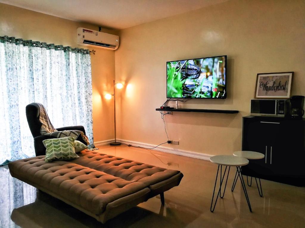 a living room with a couch and a flat screen tv at Panglao Paradise Homes in Panglao