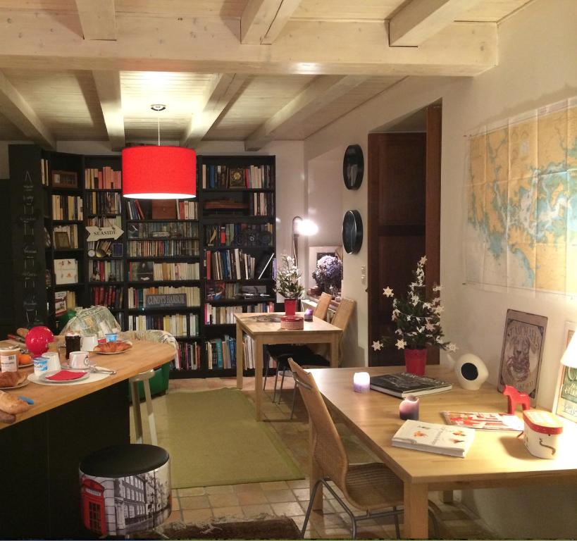 una sala de estar con 2 mesas y un estante de libros en Ar Couette en Le Bono