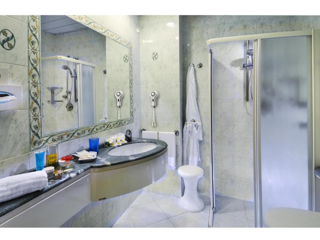 a bathroom with a sink and a shower and a toilet at Hotel Losanna in Gabicce Mare