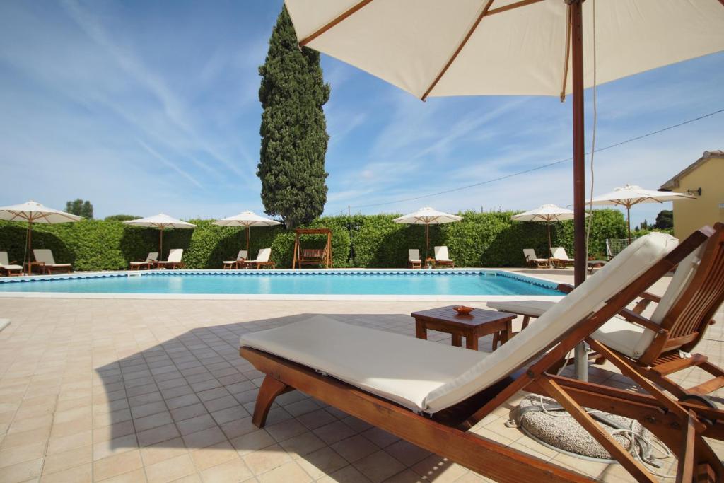 a swimming pool with a chair and an umbrella at Podere Tre Cipressi Country Resort in Campiglia Marittima