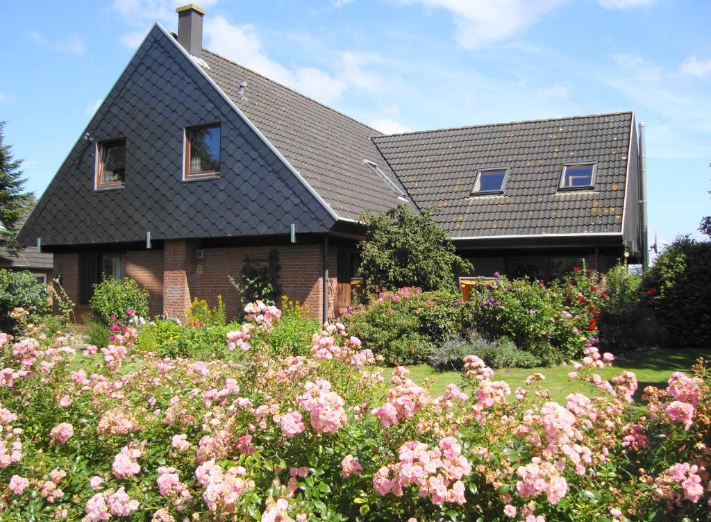 a house with a lot of flowers in front of it at Ferienwohnung Stauch in Tating