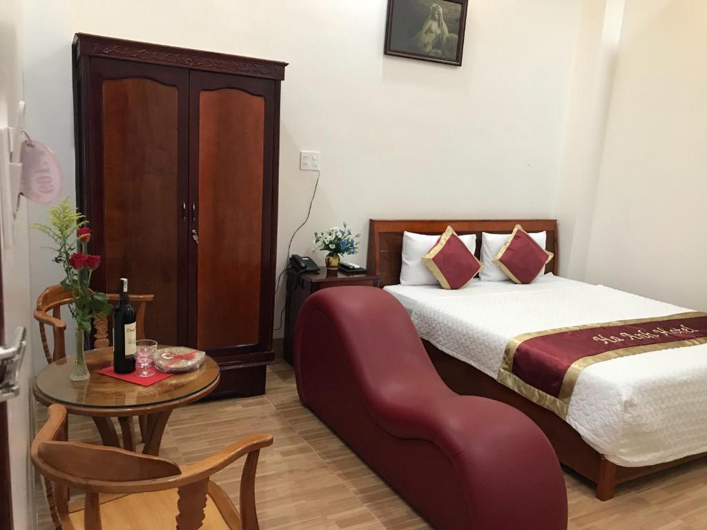 a bedroom with a bed and a table with a chair at Ha Anh Hotel in Cao Lãnh
