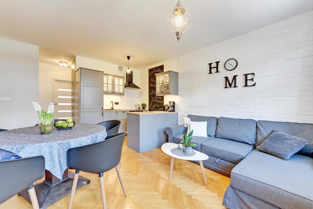 a living room with a blue couch and a table at Motława Apartment - the Best Location in Gdańsk