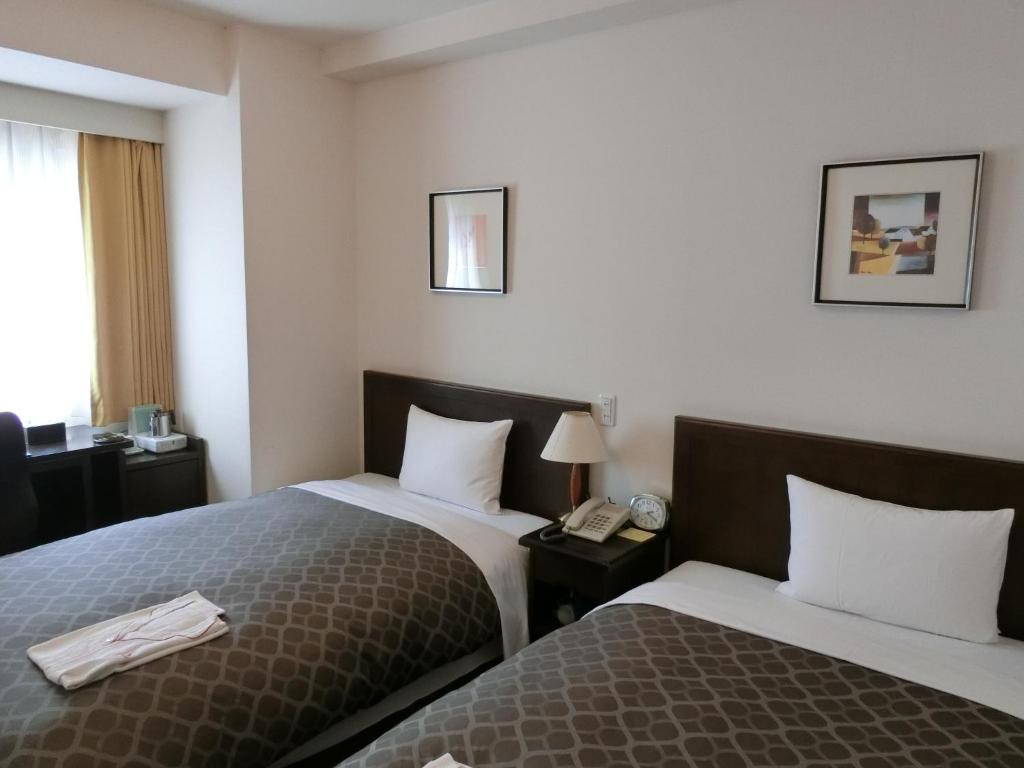 Postel nebo postele na pokoji v ubytování Laxio Inn