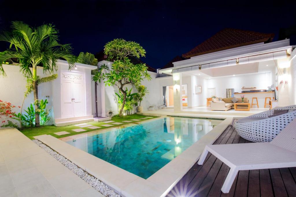 a villa with a swimming pool at night at Villa Angela in Seminyak