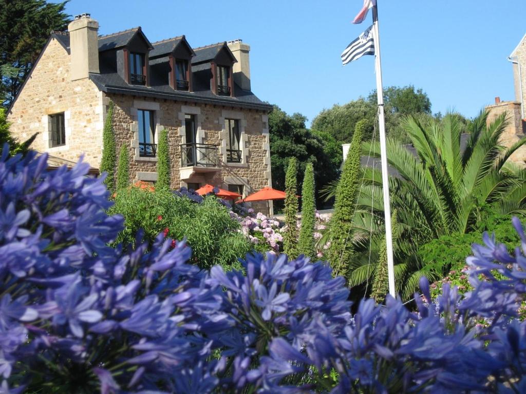 un jardin avec des fleurs violettes en face d'un bâtiment dans l'établissement Men Joliguet, sur l'Île-de-Bréhat