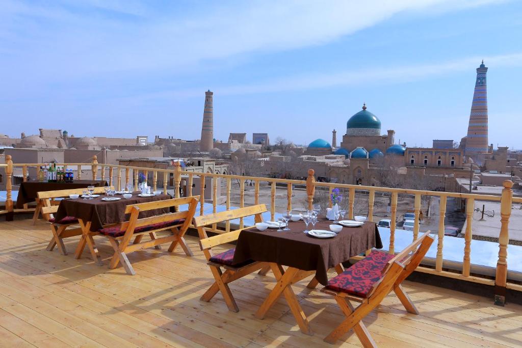 a balcony with tables and chairs with a view of a city at Arkanchi Hotel in Khiva