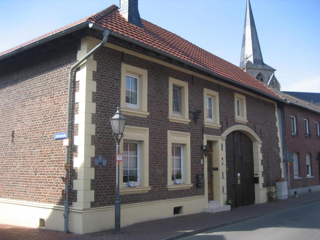 un edificio de ladrillo con una puerta grande y una iglesia en Ferienwohnung Hahnenblick, en Waldfeucht