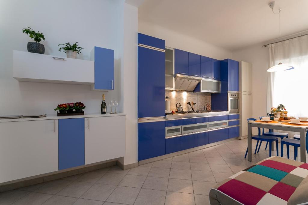 a kitchen with blue and white cabinets and a table at Park House Niguarda in Milan