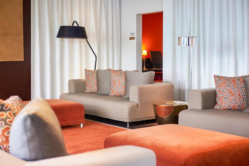 a living room with couches and chairs and a lamp at Adagio Nice Centre in Nice