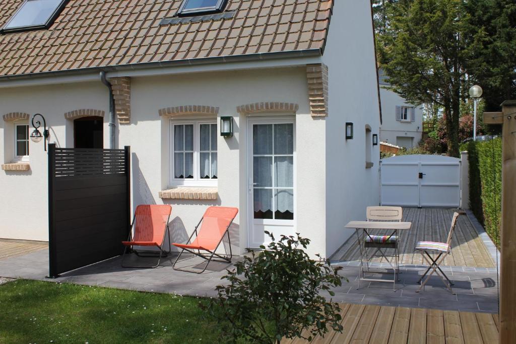 une maison avec des chaises et une table sur une terrasse dans l'établissement La Tonnelle, à Hardelot-Plage