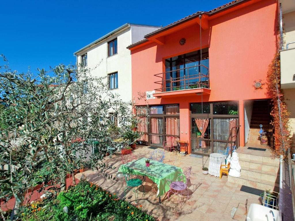 an orange house with a table in front of it at Apartments Kada 1571 in Pula