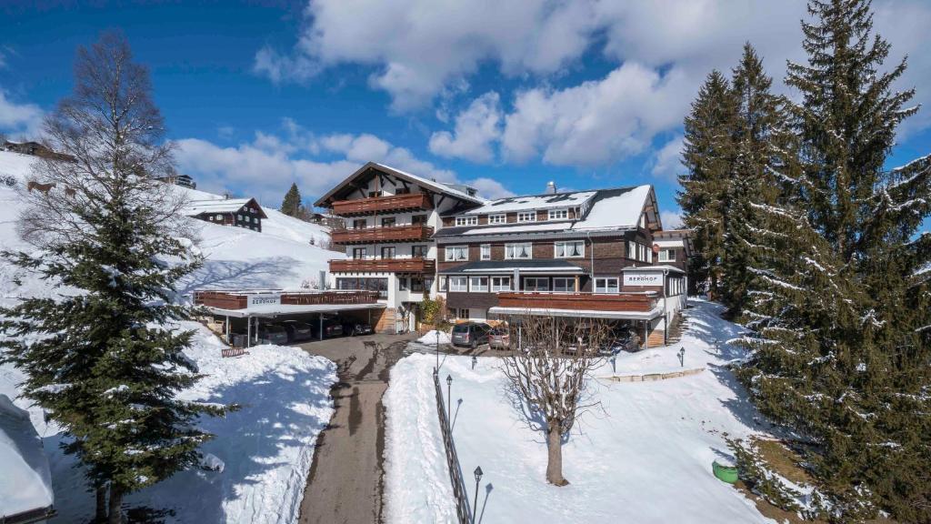 un gran lodge en la nieve con árboles nevados en Der Berghof, en Hirschegg