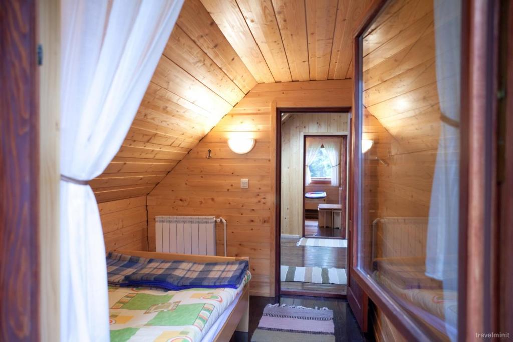 Habitación pequeña con cama en una casa de madera en Natura BH en Izvoare