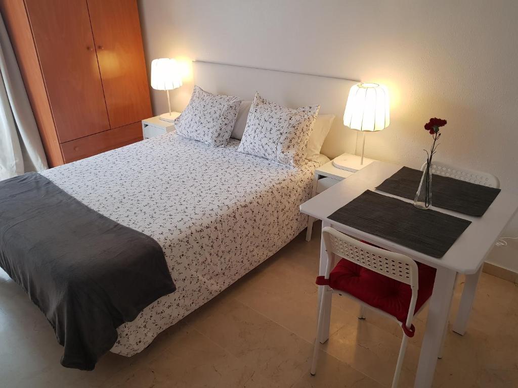 マラガにあるFan Flat Mariscalのベッドルーム1室(ベッド1台、花瓶付きのテーブル付)