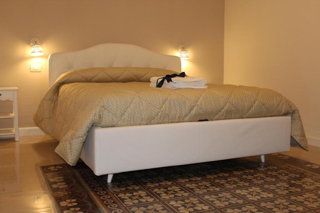 un letto bianco con un gatto seduto sopra di B&B Palazzo Rochira a Castellaneta