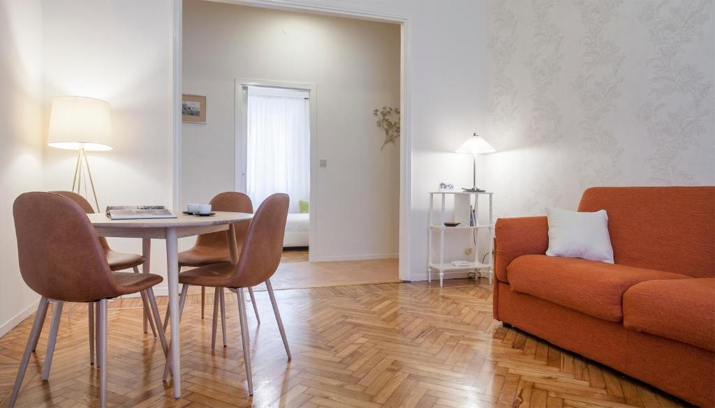 ein Wohnzimmer mit einem Tisch, Stühlen und einem Sofa in der Unterkunft Italianway-Nerino in Mailand