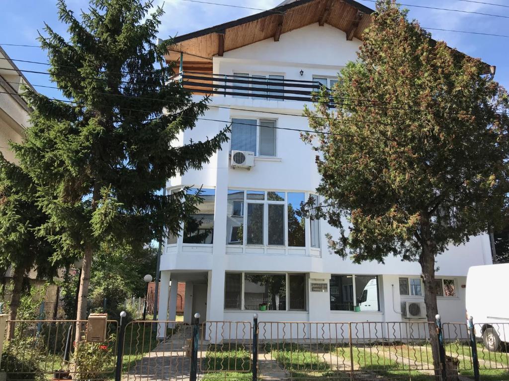uma casa branca com árvores em frente em Milena`s House em Burgas