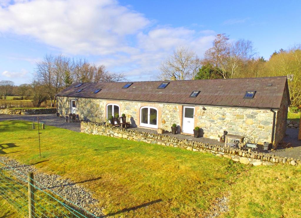 an old stone house with solar panels on it at Beudy Menai in Llanddeiniolen