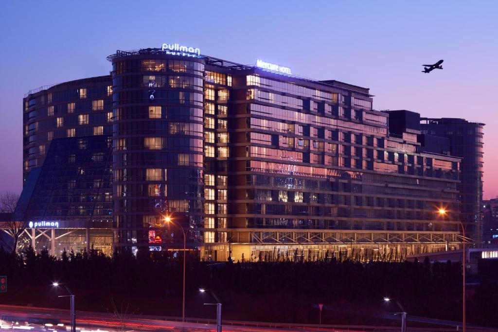 duży budynek w nocy z oświetleniem w obiekcie Mercure Istanbul West Hotel & Convention Center w Stambule