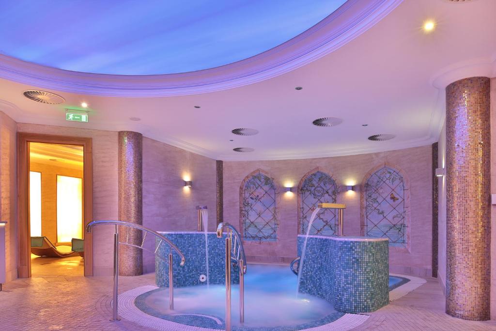 a room with a pool of water in a building at Retro Riverside Wellness Resort in Karlovy Vary