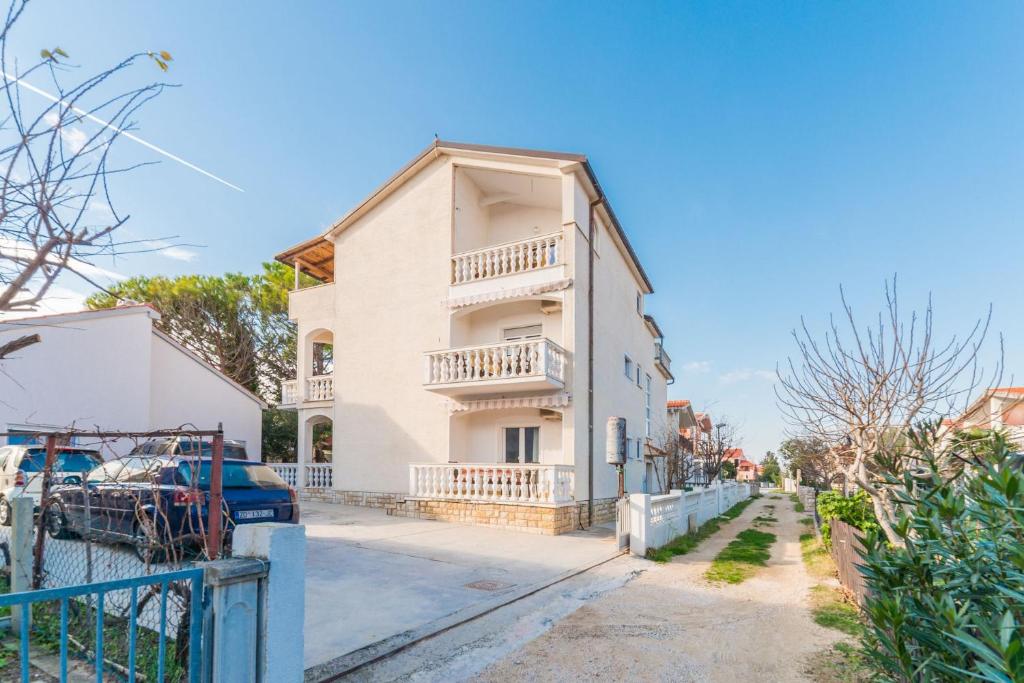 an apartment building with a balcony on a street at Apartments Ivica - with parking in Nin