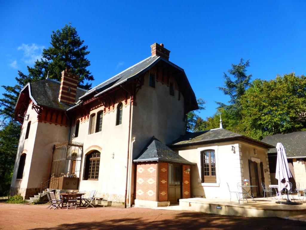 ein großes weißes Haus mit einem Dach in der Unterkunft Le Manoir sur la Roche in Clermain