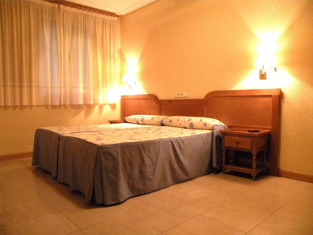 A bed or beds in a room at Hostal Benamar