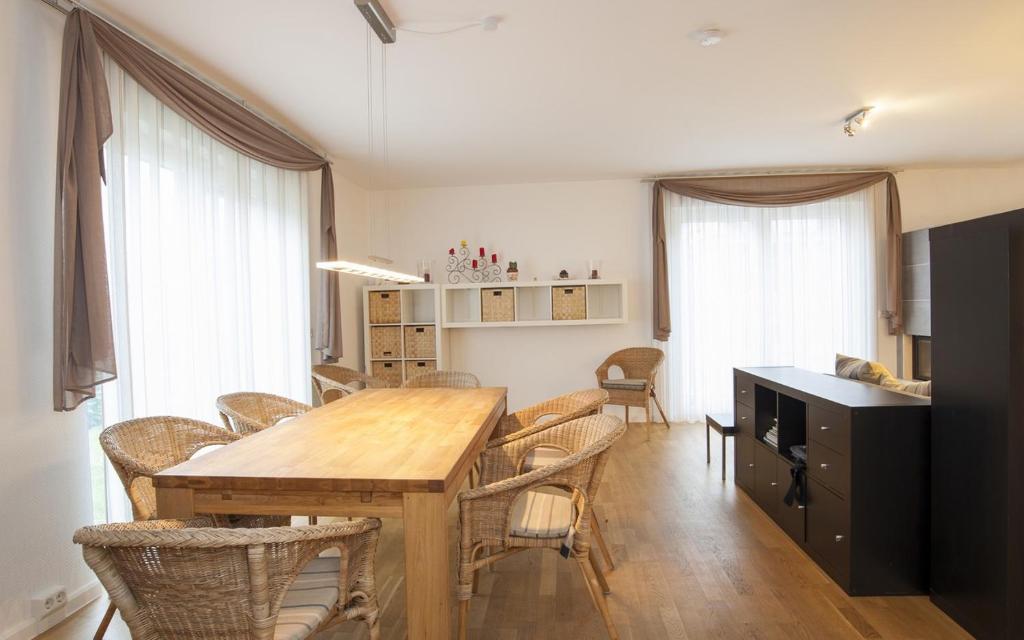 Ferienhaus Mainz في ماينز: غرفة طعام مع طاولة وكراسي خشبية