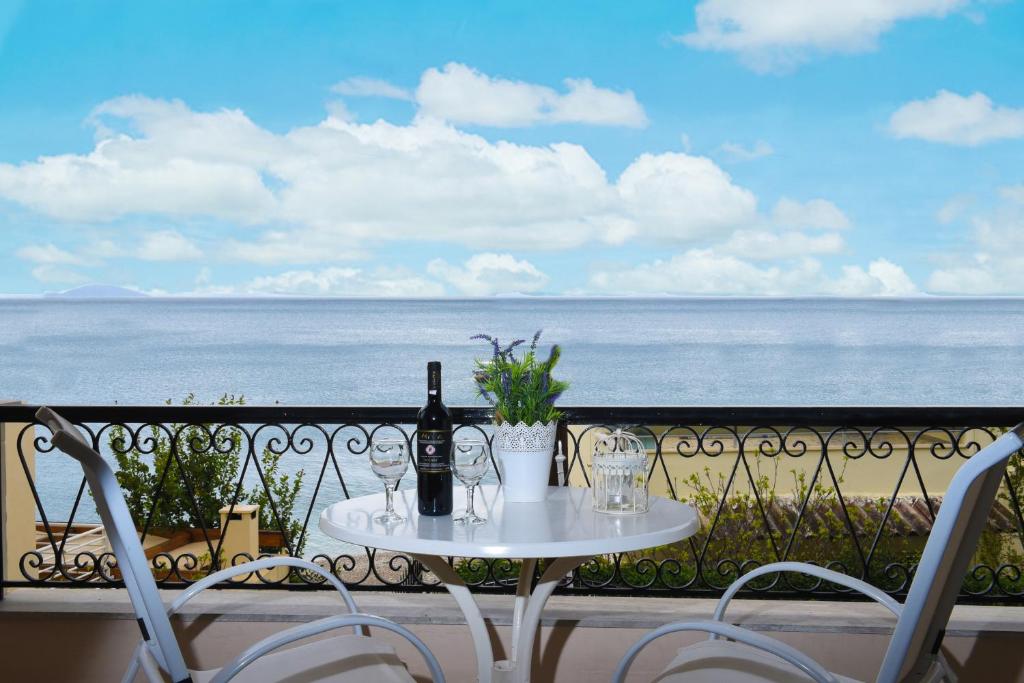 una mesa con botellas de vino y copas en el balcón en Fotopoulos Apartments, en Xiropigado