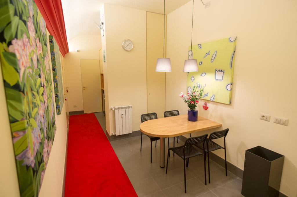 Zimmer mit einem Tisch, Stühlen und einem roten Teppich in der Unterkunft tiaspettoaroma in Rom