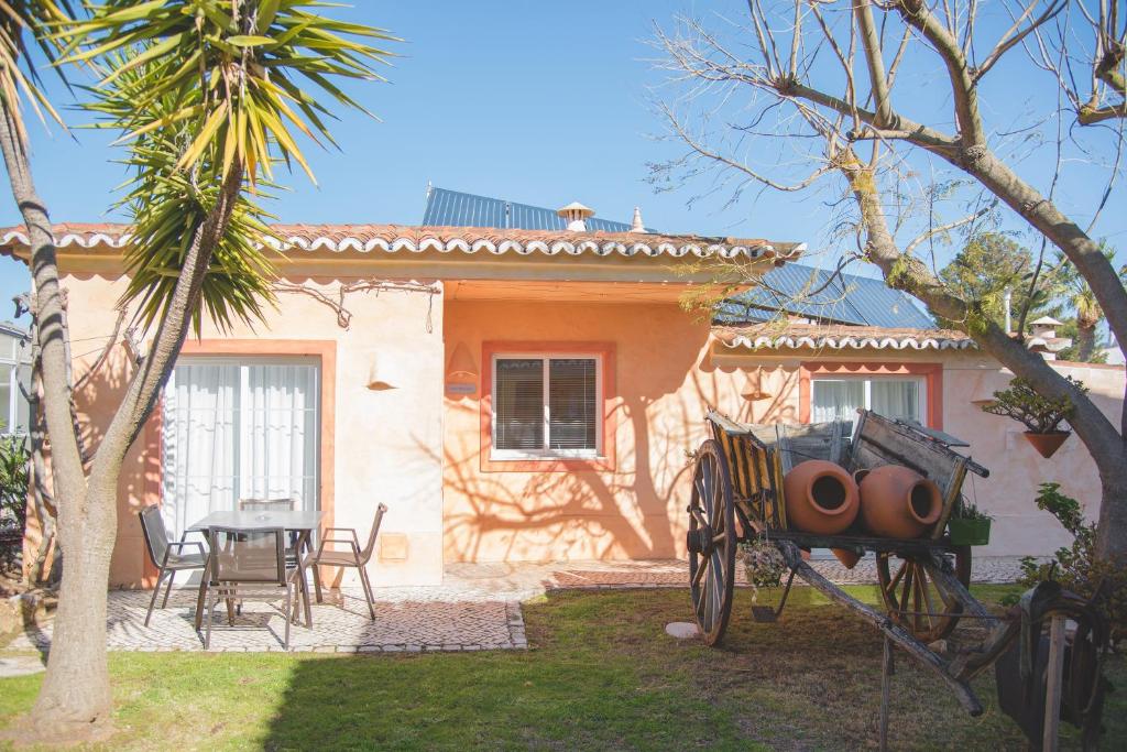 a small house with a table and chairs in a yard at Costa d'Oiro Ambiance Village in Lagos