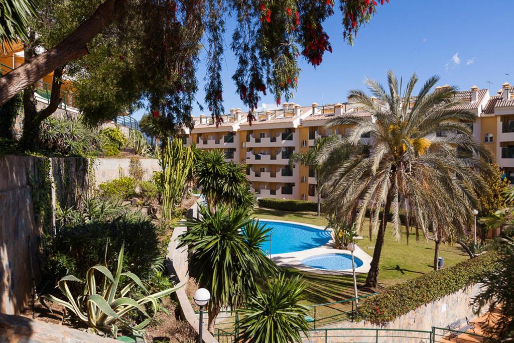 un edificio de apartamentos con piscina y palmeras en Señorío de Aloha Apartahotel, en Marbella