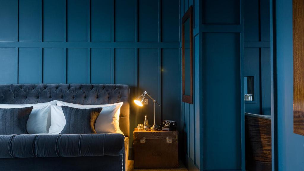 a blue bedroom with a bed and a table with a lamp at Number 38 Clifton in Bristol