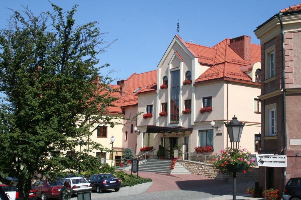 a building with red roofs on a city street at Hotel Basztowy in Sandomierz