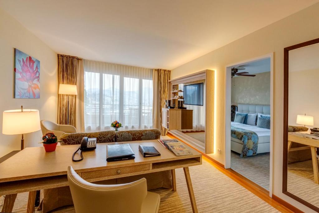 una camera da letto con scrivania di Suitenhotel Parco Paradiso a Lugano
