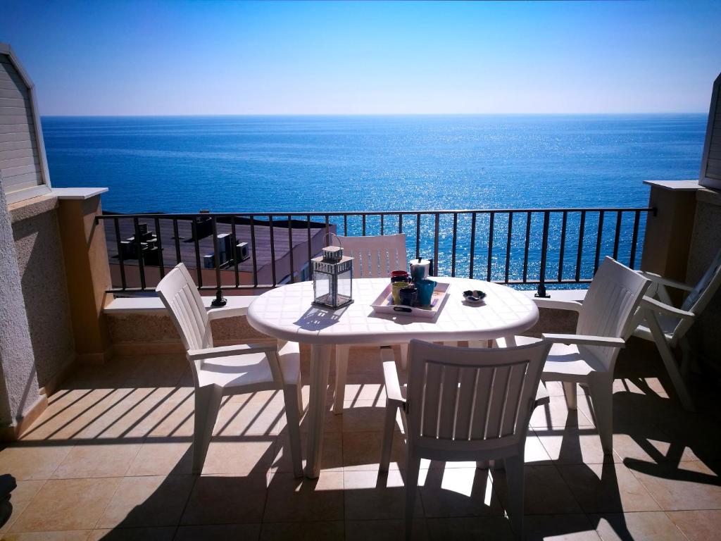 Una mesa y sillas en un balcón con vista al mar. en NAUTILUS VISTAS MAR, NUEVO Centro Salou, en Salou