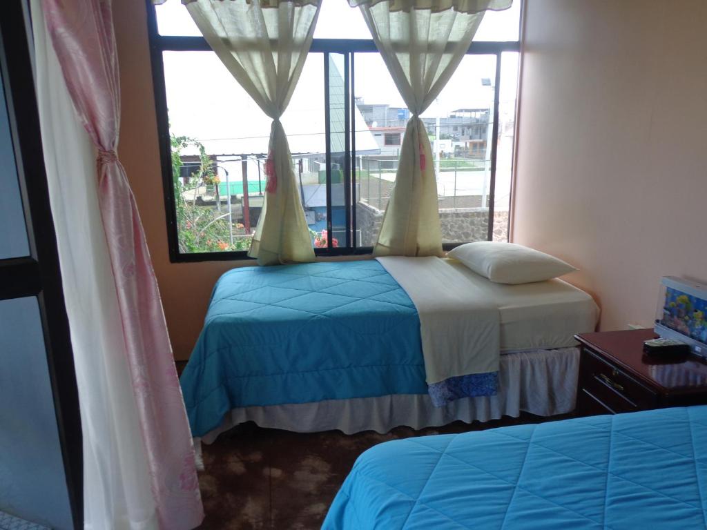 Postel nebo postele na pokoji v ubytování Hostal Nathaly