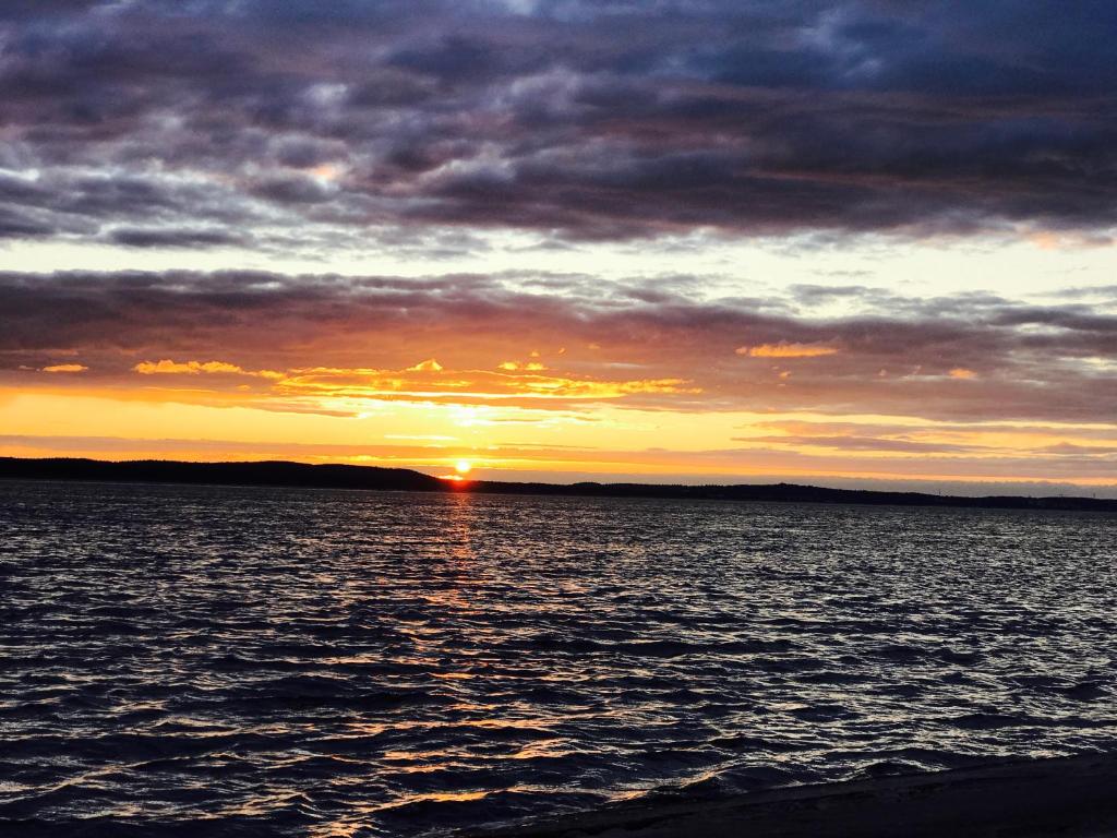 una puesta de sol sobre un gran cuerpo de agua en Apartament Aleksandra, en Świnoujście