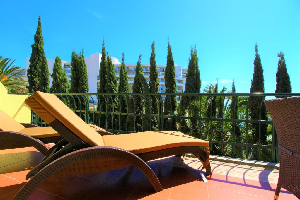 un patio con sedie e alberi su un balcone di Central Sea View a Funchal